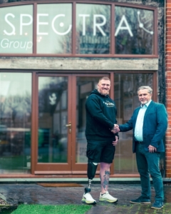 Aaron Moon shakes hands with Spectra Group CEO Simon Davies outside Spectra Group headquarters.